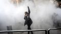 iran protest frau hebt faust in tränengas